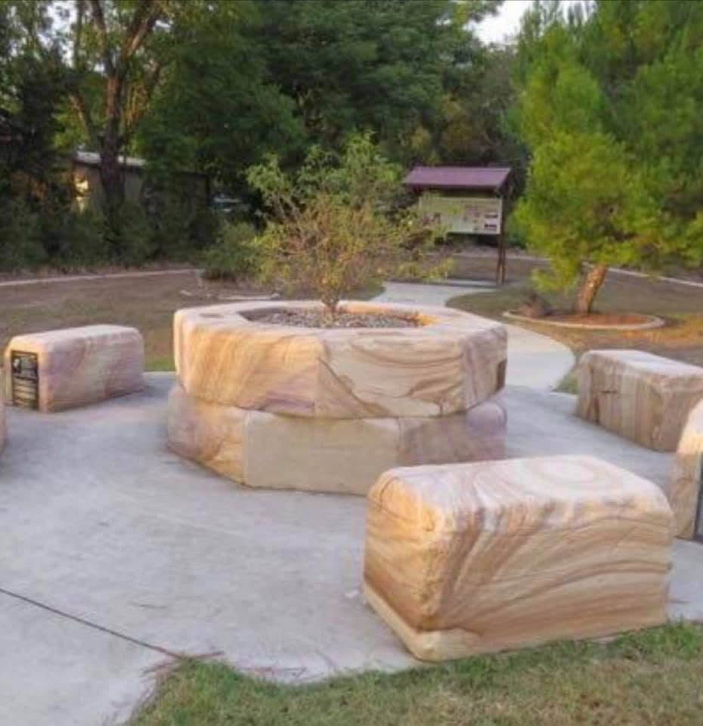 Sandstone seating and a fire pit built with their stone in a public park