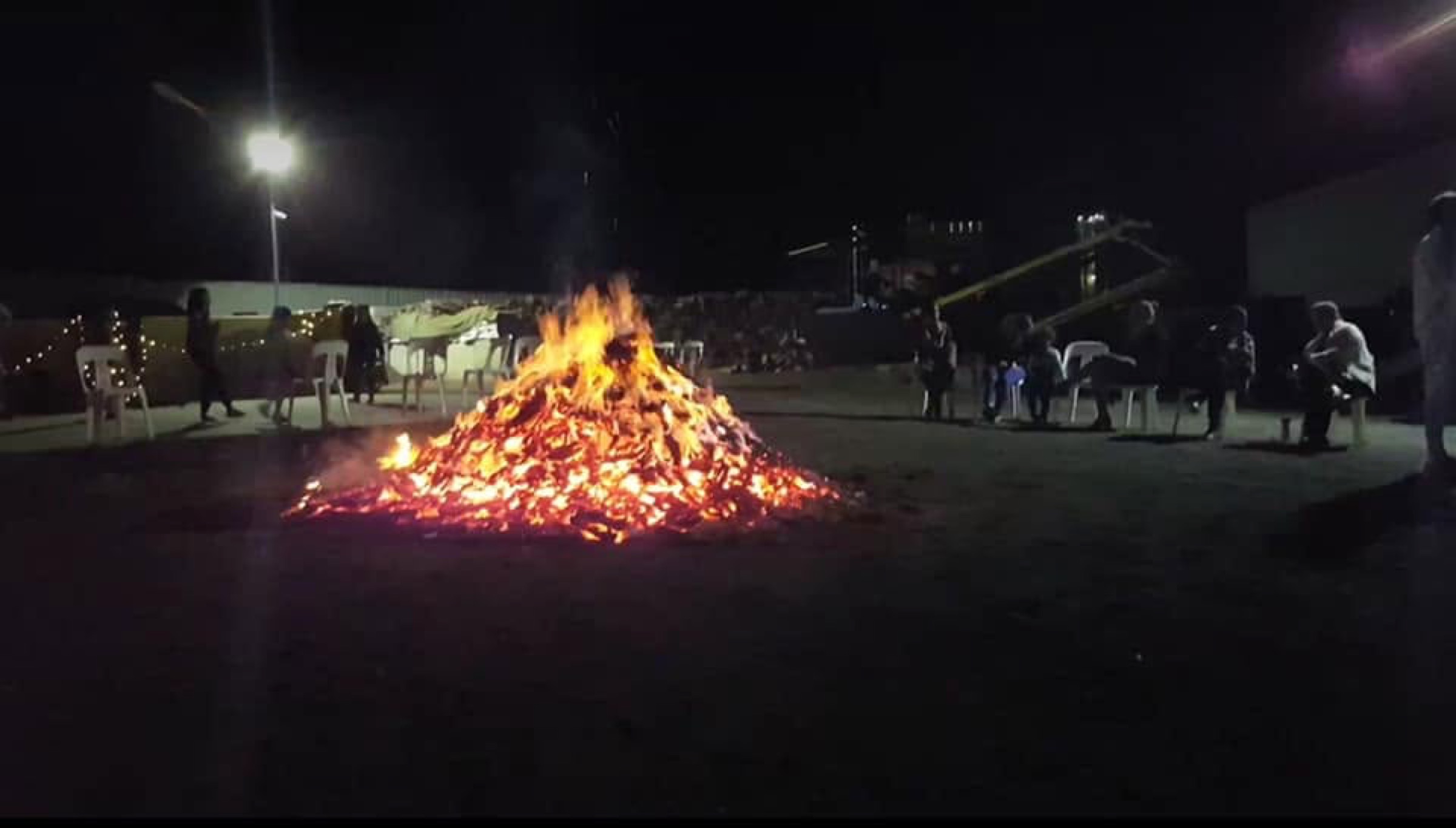 A community bonfire at night, burning wood supplied by Macca's Mulch Firewood & Gravel