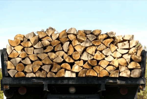 Freshly split hardwood firewood stacked densely on a trailer