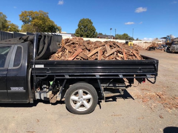 A ute loaded with freshly split firewood in the yard