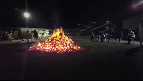 A community bonfire at night, burning wood supplied by Macca's Mulch Firewood & Gravel