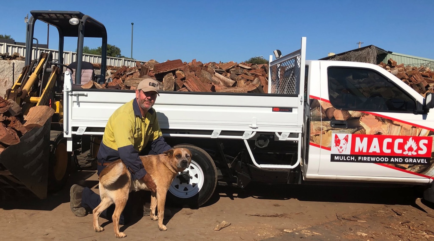 The owner with the mascot dog beside the branded ute and loader at Macca's Mulch Firewood & Gravel