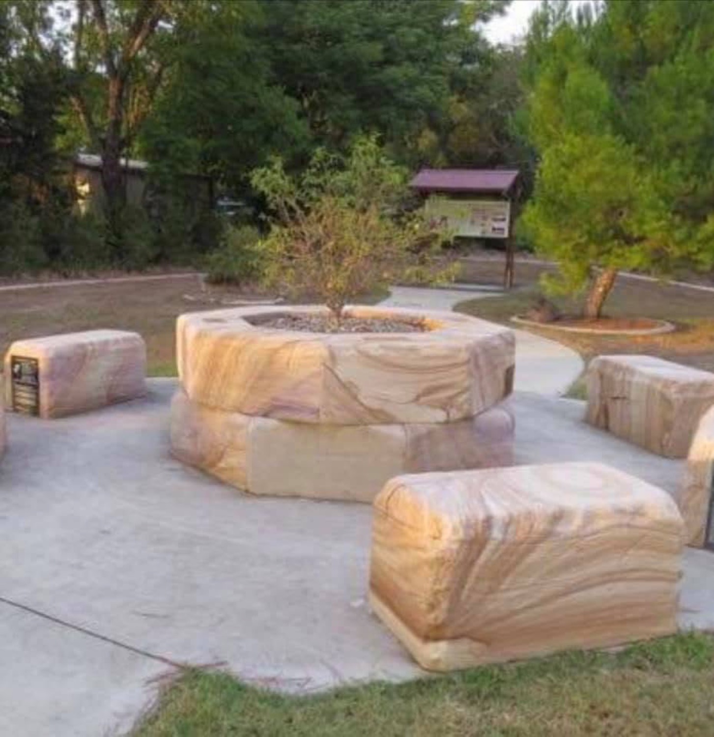 Sandstone seating and a fire pit built with their stone in a public park